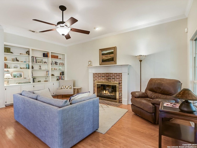 living room featuring crown molding, ceiling fan, light hardwood / wood-style floors, and a brick fireplace