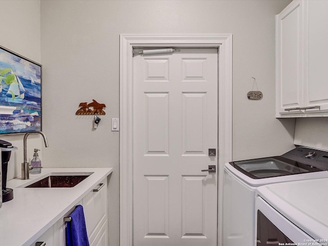 laundry area featuring washer and dryer, sink, and cabinets