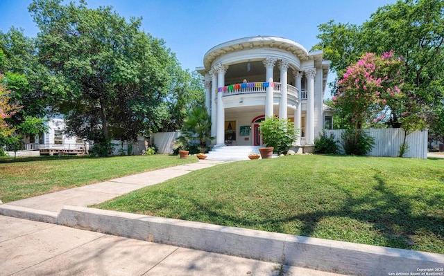 neoclassical / greek revival house featuring a front lawn and a balcony