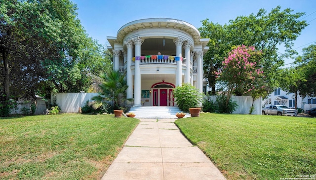 exterior space featuring a lawn and a balcony