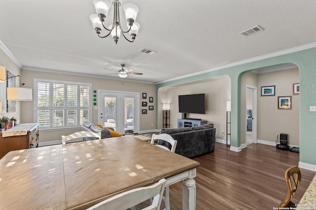 dining area with ornamental molding, dark hardwood / wood-style floors, ceiling fan with notable chandelier, and a textured ceiling