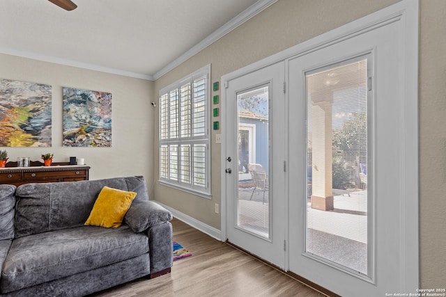 doorway to outside with ornamental molding and light hardwood / wood-style flooring