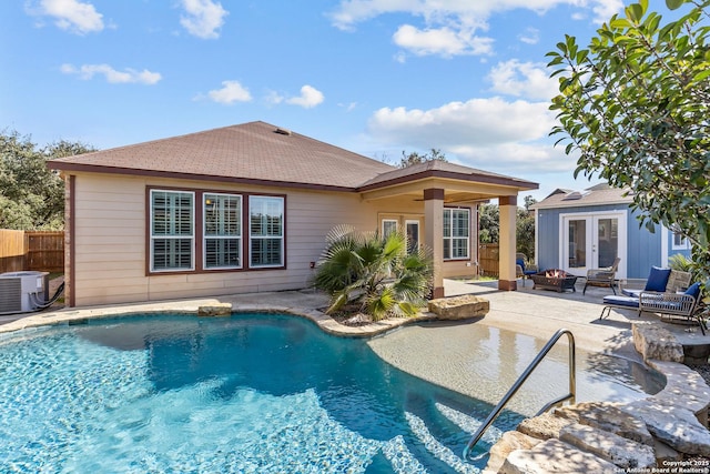 view of swimming pool featuring french doors, a patio, central AC unit, and an outdoor fire pit