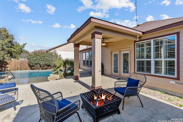 view of patio with a fenced in pool, ceiling fan, and a fire pit