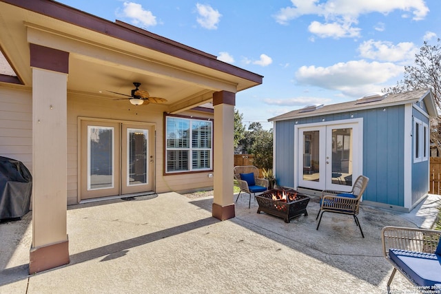 view of patio / terrace featuring ceiling fan, an outdoor fire pit, an outdoor structure, grilling area, and french doors