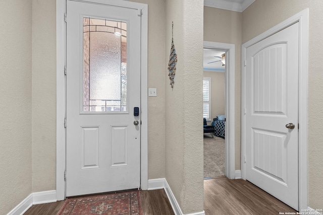 entryway with ornamental molding and hardwood / wood-style floors