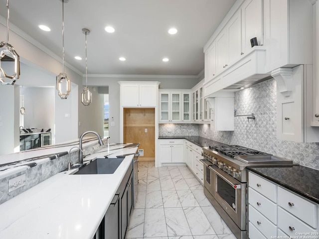 kitchen featuring decorative light fixtures, sink, white cabinets, dark stone counters, and double oven range