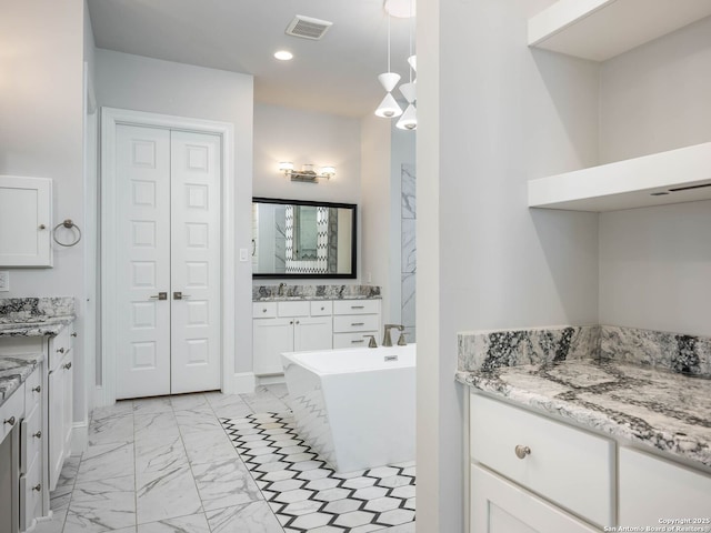 bathroom featuring vanity and a washtub