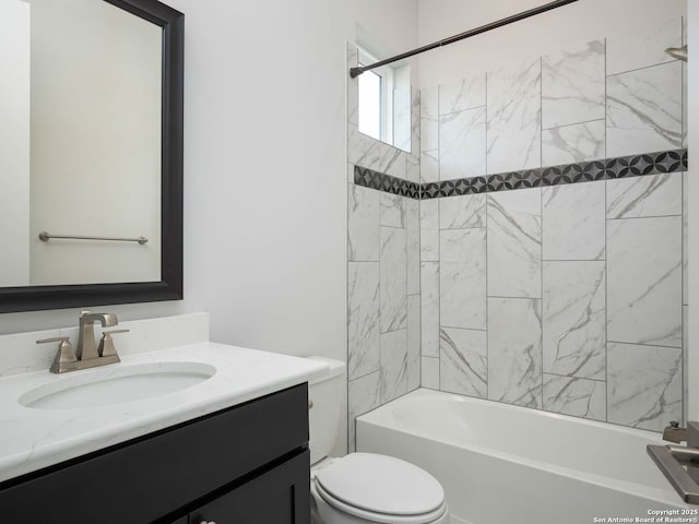 full bathroom featuring tiled shower / bath, vanity, and toilet