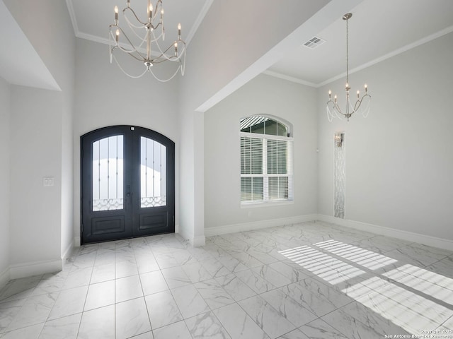 entrance foyer with french doors, a wealth of natural light, crown molding, and a notable chandelier