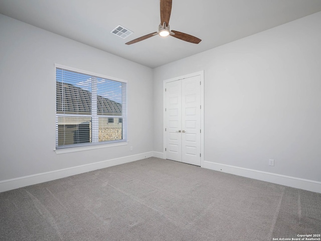 unfurnished bedroom featuring carpet floors, a closet, and ceiling fan