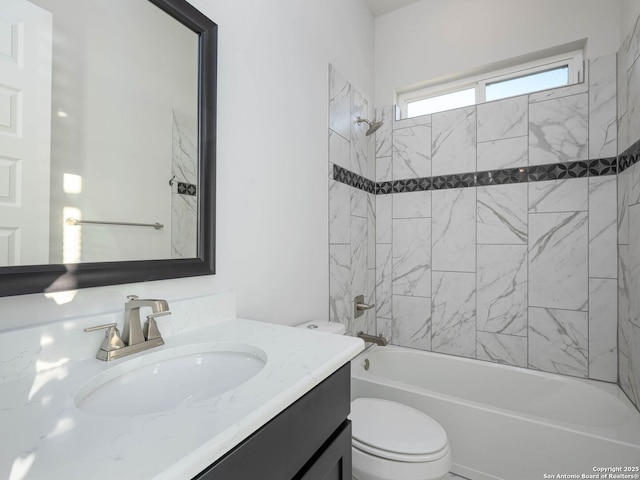 full bathroom with vanity, tiled shower / bath combo, and toilet