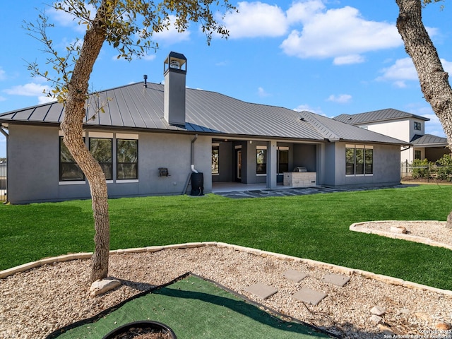 back of property featuring a patio, an outdoor kitchen, and a yard