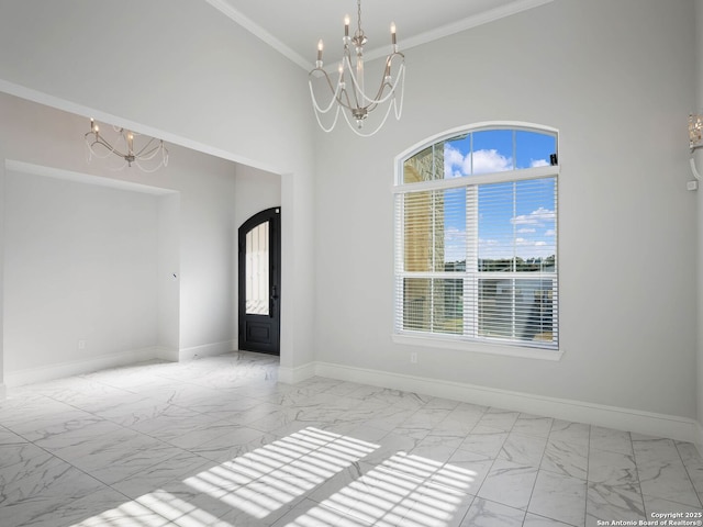 spare room with ornamental molding and an inviting chandelier