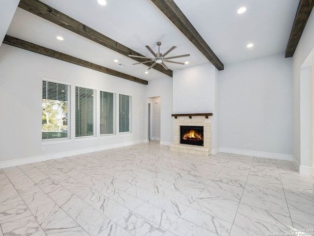 unfurnished living room with beam ceiling, a fireplace, and ceiling fan