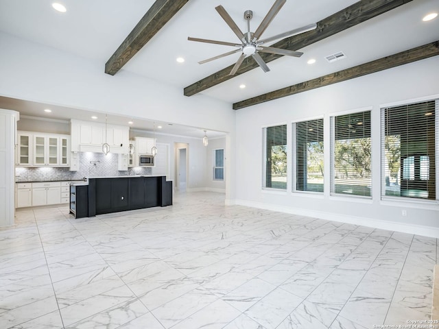 unfurnished living room featuring ceiling fan and beam ceiling