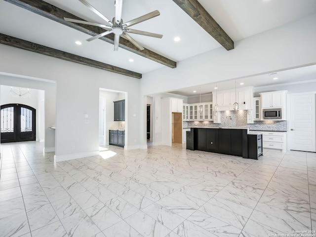 unfurnished living room featuring beamed ceiling, ceiling fan, and french doors