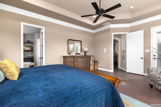 bedroom featuring ensuite bath, crown molding, ceiling fan, a tray ceiling, and dark hardwood / wood-style flooring