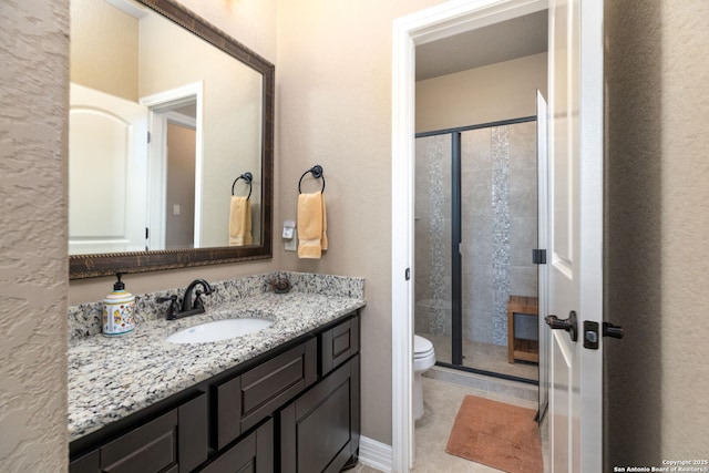 bathroom with vanity, tile patterned flooring, a shower with door, and toilet