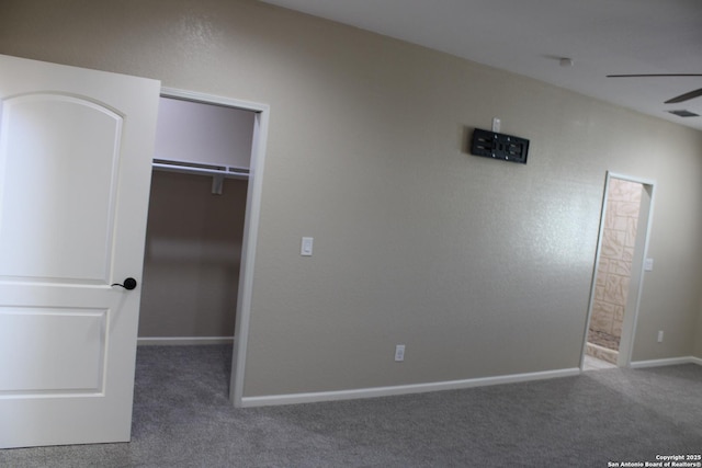 unfurnished bedroom with a spacious closet and carpet flooring