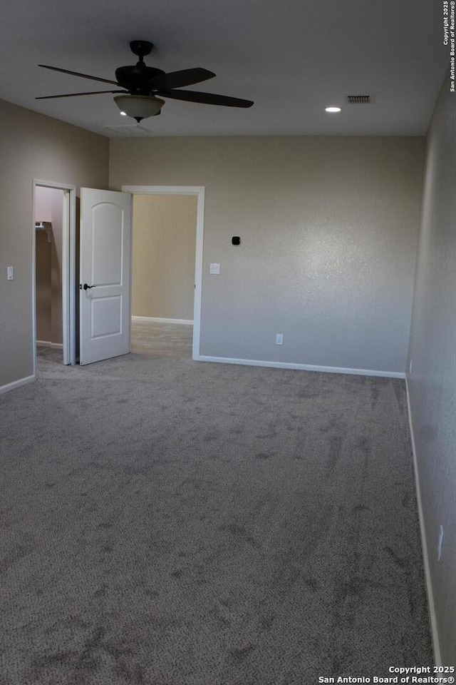 carpeted spare room featuring ceiling fan