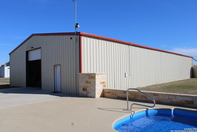 view of outbuilding with a fenced in pool