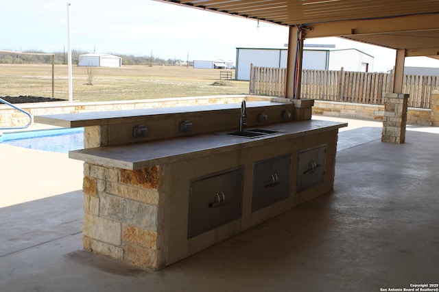 view of patio featuring an outdoor kitchen and sink