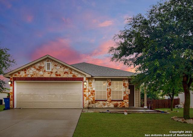 ranch-style home featuring a garage and a lawn