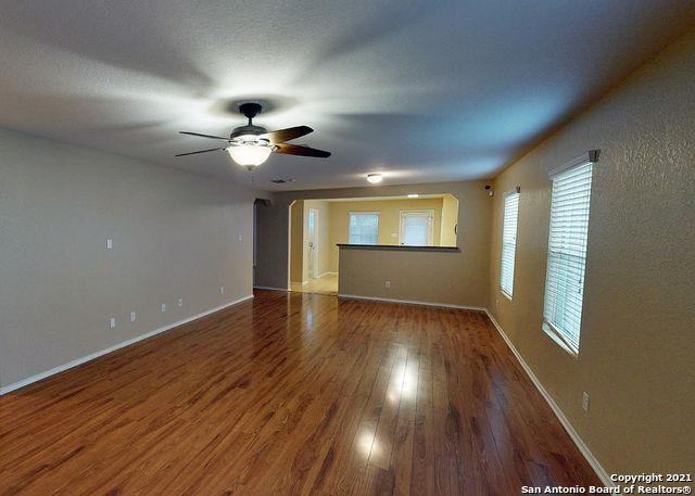 empty room with ceiling fan and wood-type flooring