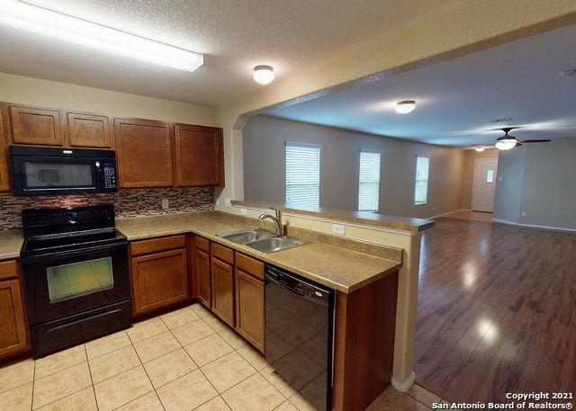 kitchen with sink, backsplash, black appliances, a textured ceiling, and kitchen peninsula