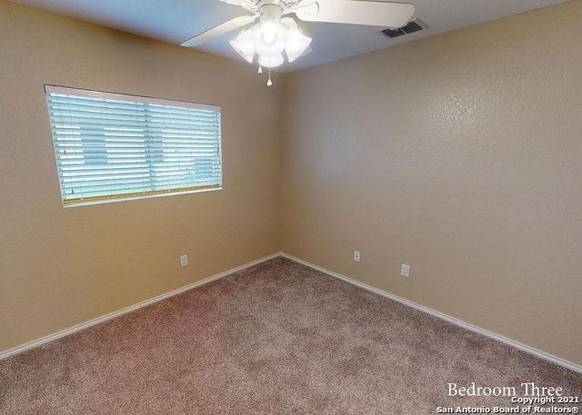 carpeted spare room with ceiling fan