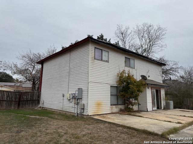 rear view of property featuring central AC, a yard, and a patio area