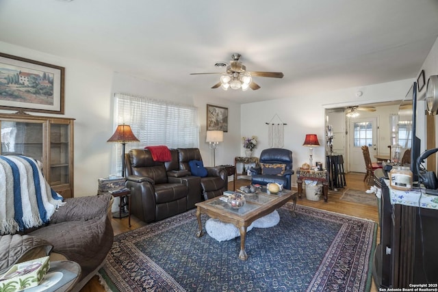 living room featuring wood-type flooring and ceiling fan