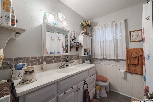 bathroom featuring vanity, hardwood / wood-style floors, decorative backsplash, and toilet