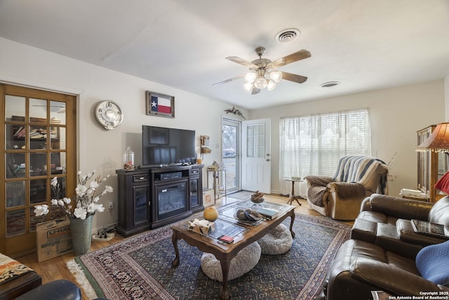 living room featuring wood-type flooring and ceiling fan