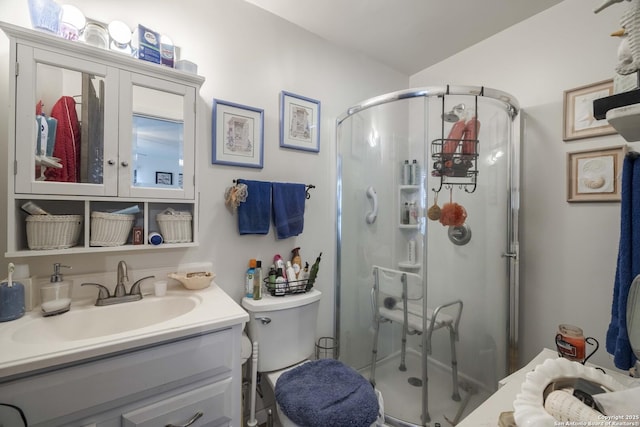 bathroom with an enclosed shower, vanity, and toilet