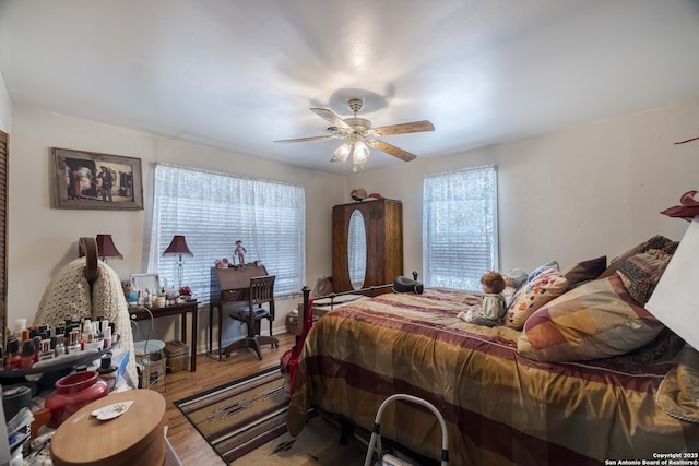 bedroom with hardwood / wood-style flooring, ceiling fan, and multiple windows