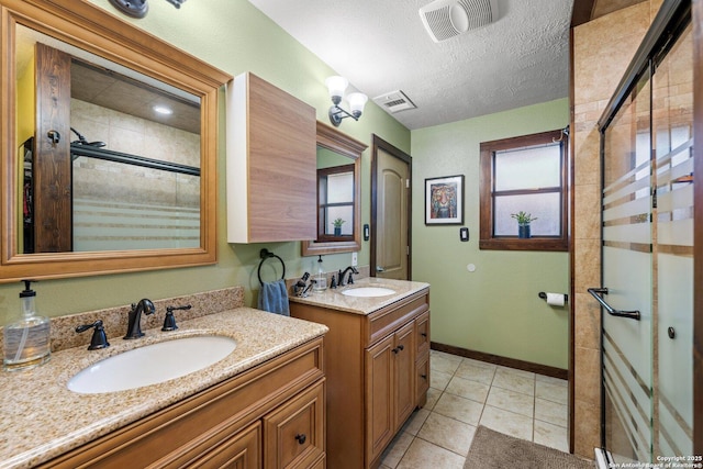 bathroom with vanity, tile patterned flooring, a textured ceiling, and walk in shower