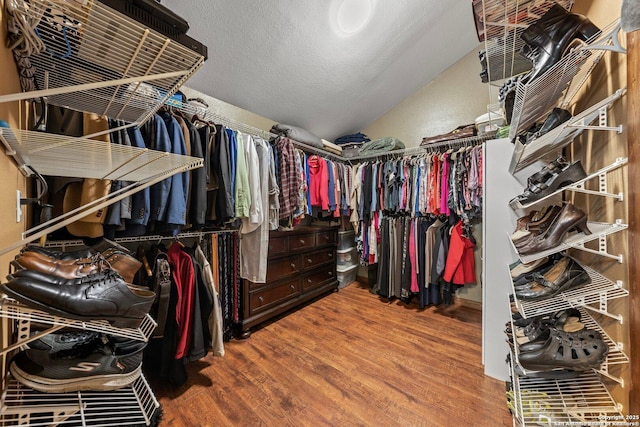 walk in closet featuring lofted ceiling and hardwood / wood-style flooring