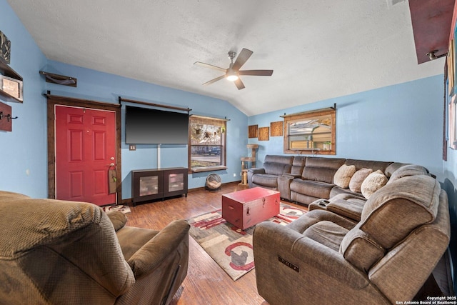 living room featuring ceiling fan, lofted ceiling, wood-type flooring, and a textured ceiling