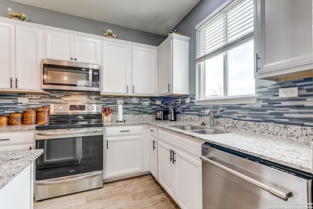 kitchen featuring appliances with stainless steel finishes, sink, white cabinets, and backsplash