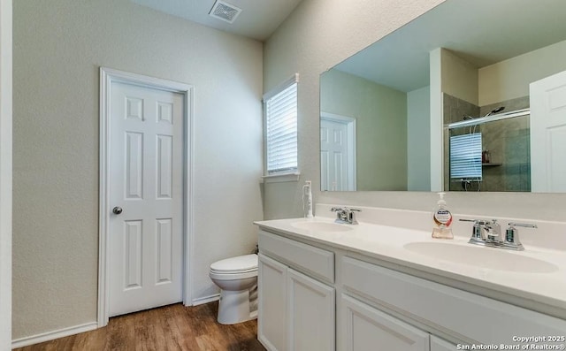 bathroom with walk in shower, wood-type flooring, toilet, and vanity