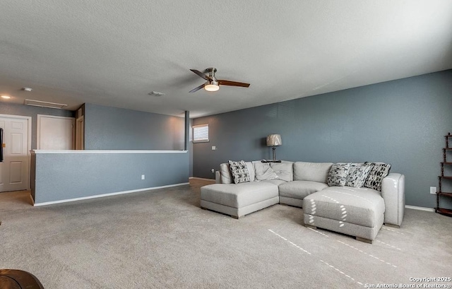 carpeted living room with ceiling fan and a textured ceiling