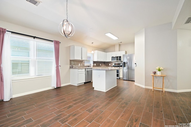 kitchen featuring tasteful backsplash, lofted ceiling, visible vents, appliances with stainless steel finishes, and white cabinets