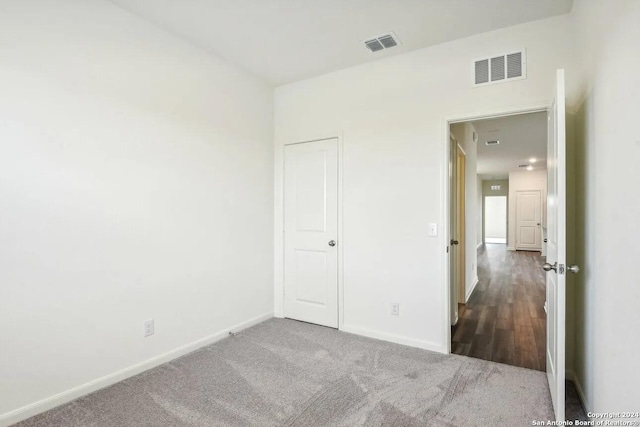 unfurnished bedroom with dark colored carpet