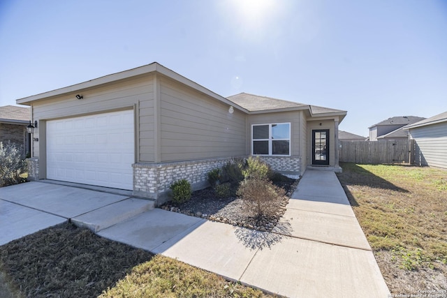 single story home with a garage and a front lawn