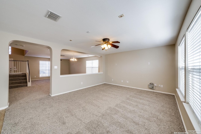 unfurnished room with carpet flooring and ceiling fan with notable chandelier