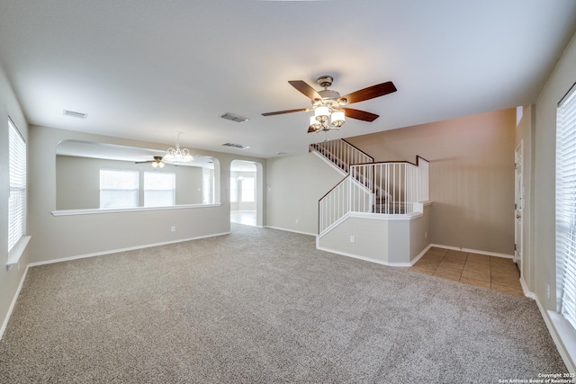 unfurnished living room with carpet floors, a wealth of natural light, and ceiling fan