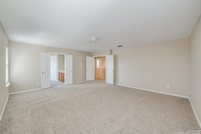 unfurnished room featuring light carpet