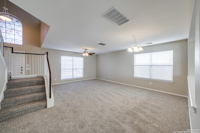 unfurnished living room featuring ceiling fan with notable chandelier and carpet